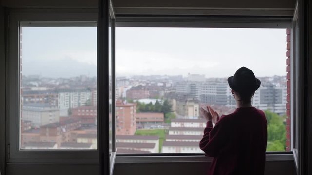 Young girl in Spain applauds from her window in recognition and support of public health officials who fight against the coronavirus.