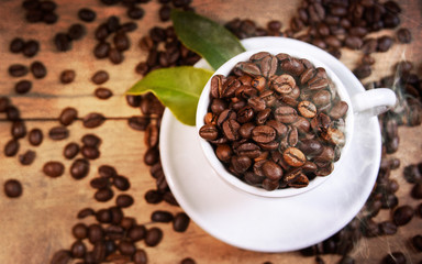 Coffee cup and beans on old kitchen table.