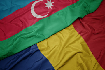 waving colorful flag of romania and national flag of azerbaijan.