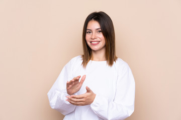Young woman over isolated background applauding