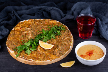 Meat pizza with meat mince, with parsley and lemon slice, served with puree soup and a glass of compote