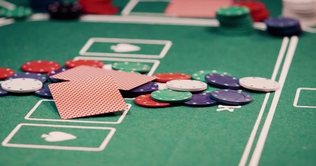 Close up of two poker cards got passed in the middle of the poker table on a heap of chips shot in 4k super slow motion