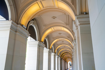 Fototapeta premium Long exterior portico of old Melbourne General Post Office Building with row of repeating illuminated arches