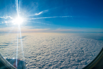 The bright sun shining in the window of an airplane