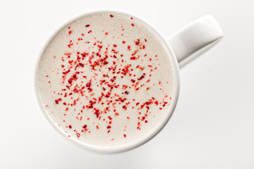 Top view of Craft latte coffee with berries powder on top in white ceramic mug. White background. Best for commercial. Content for coffee addicted guys