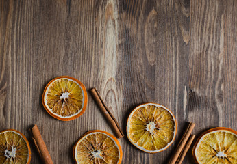 Orange chips with cinnamon close up on a brown wooden background with copy space