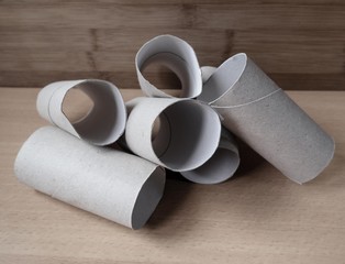 Structure made out of toilet paper rolls with a wood background. In times of lack of toilet paper because of the covid 19.