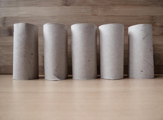 Structure made out of toilet paper rolls with a wood background. In times of lack of toilet paper because of the covid 19.