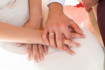 Obraz na płótnie Canvas manos de recién casados entrelazadas enseñando los anillos
