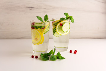 Sassy diet water. Cucumber, lemon, mint lemonade in glasses on light background