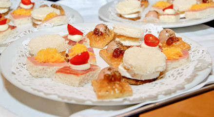 Bola de foie gras sobre un hojaldre en el centro de un plato rodeado de otros deliciosos canapés.