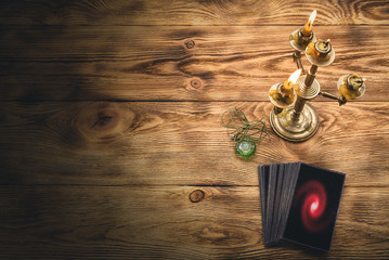 Tarot cards deck on the old brown wooden table background.