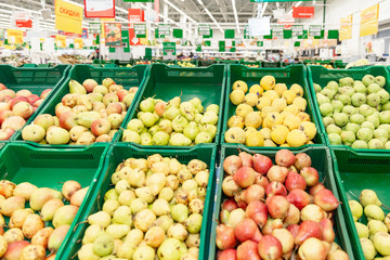 A variety of fruits in boxes in a large hypermarket. Healthy eating and vegetarianism.