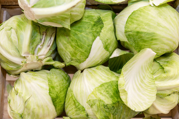 Green heads of fresh cabbage on a store counter. Close-up. Top view. Healthy eating and vegetarianism.