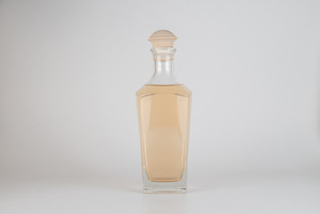 Glass bottle on light background. Closeup studio design object shot.