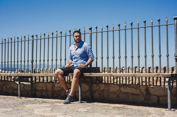 young man sitting on a fence