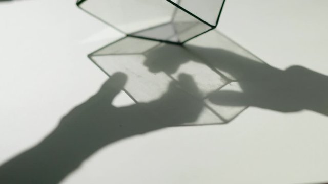 daylight effect, shadow from the hands of a couple on the background of a glass cube