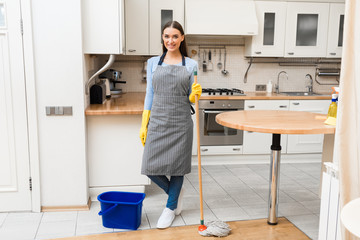 Young woman holding mop to clean floor