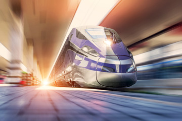 High speed train on a clear day with motion blur at the city station - obrazy, fototapety, plakaty
