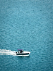 Speeding motorboat on azure water - obrazy, fototapety, plakaty