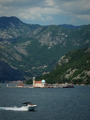Speeding motorboat near the island in Kotor bay