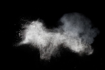White dust is scattered by an explosion on a black background, an abstract cluster of white particles, a snowstorm on a black background