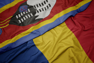 waving colorful flag of romania and national flag of swaziland.