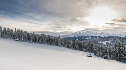 Winter landscape in the mountains and wood cabin