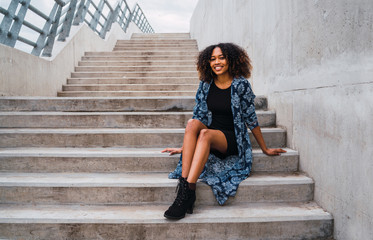Afro-american woman sitting on steps.