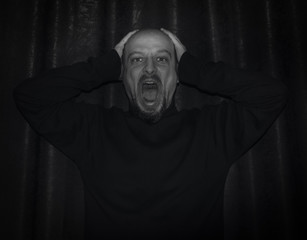 Fototapeta premium Man with the hands on his head and screaming in despair.