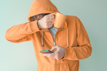 Man drinking coffee and using mobile phone in morning