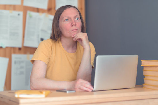 Thoughtful female freelance translator working in home office