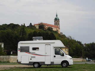 camper on the background of the castle - obrazy, fototapety, plakaty