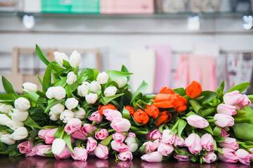 A huge multicolor bouquet of tulips lay on table.