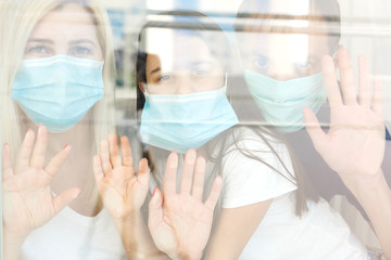 Family, standing behind the window, at home, quarantine due to coronavirus