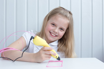 The girl is engaged with a 3D pen. Light background. Selective focus. Classes at home.