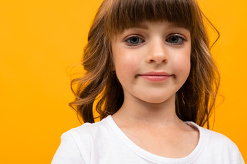 Beautiful little girl in dress isolated on yellow or orange background