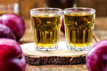 alcoholic drink made from plum, fruit liqueur with rustic wooden background.