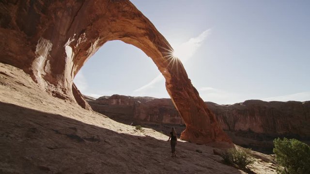 Hiker approaches Corona Arch near Moab Utah