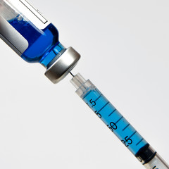 Close-up of a syringe and a vial of injectable solution