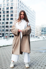 young pretty teenage girl posing cheerful happy smiling wearing street style outside in europe city, lifestyle people concept