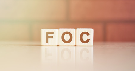 FOC acronym concept. Text on wooden cubes with bright light