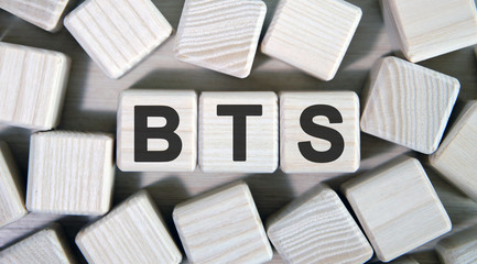 BTS text on wooden square cubes surrounded by other cubes