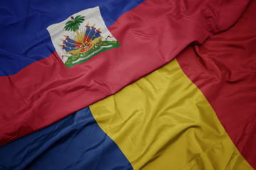 waving colorful flag of romania and national flag of haiti.
