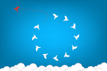 Think differently concept. Be different. Red bird changing direction. New idea, change, trend, courage, creative solution, innovation and unique way concept	