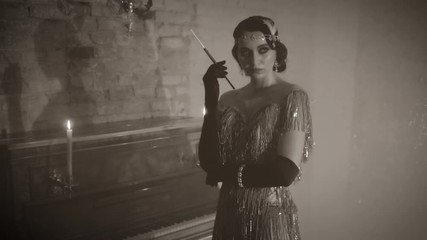  Black, white old-fashioned 30s movie. Portrait young beautiful sexy retro woman. Lady hairstyle finger wave vintage headband. Fashion silver dress. Backdrop room piano romantic bright candles burn