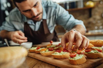 Papier Peint photo Lavable Snack Close-up of man preparing bruschetta with healthy ingredients.