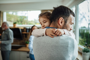 Affectionate daughter embracing her father with eyes closed.