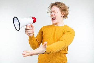 blond wavy guy shouting news into a loudspeaker on a white studio background