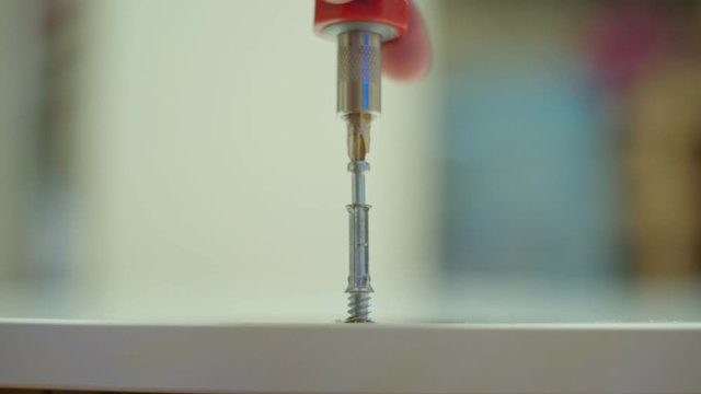 Assambling furniture at home, screwing minifix